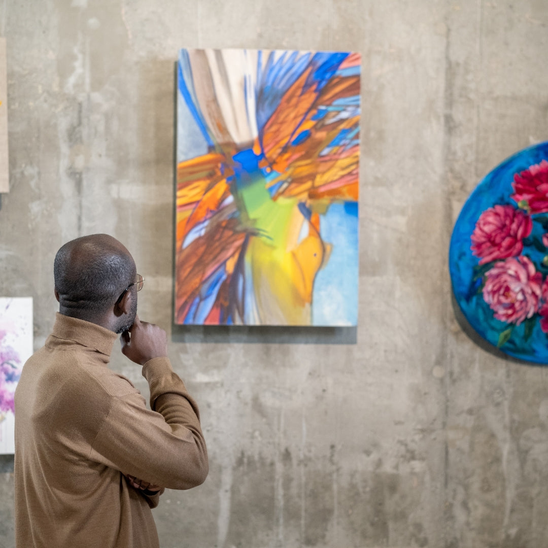 Man looking at a colorful abstract painting on a textured wall
